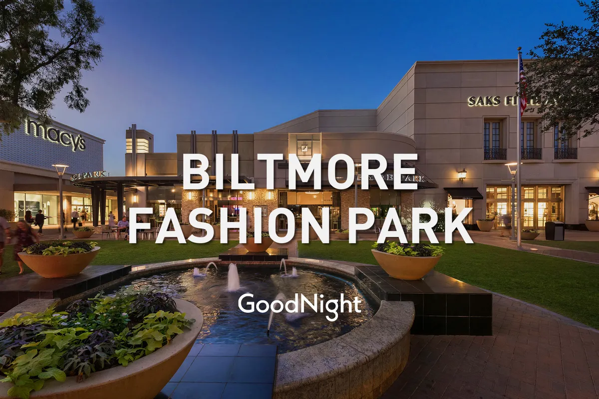 A lively plaza with a central fountain, warmly lit storefronts, elegant landscaping, and people enjoying the evening. The ambiance is sophisticated yet inviting, with visible opportunities for outdoor dining and socializing.