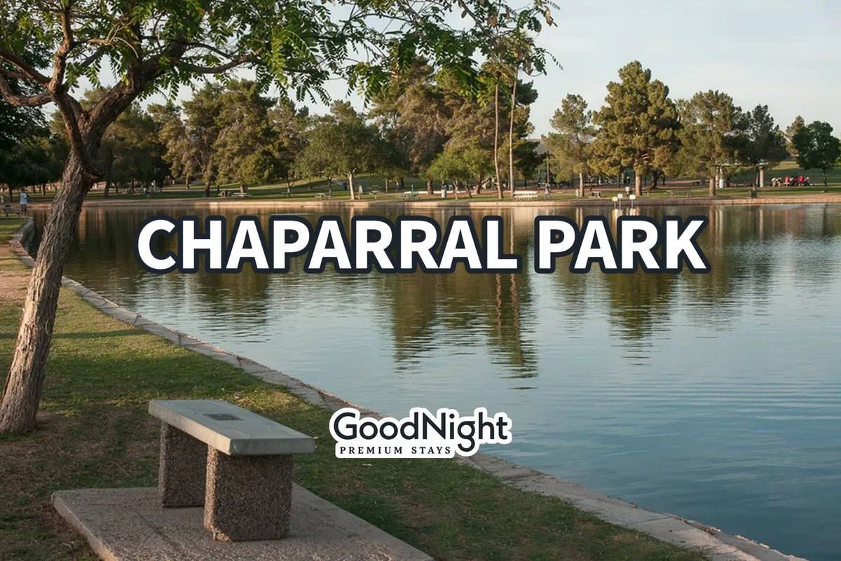 A peaceful lakeside setting with calm water, lush greenery, and a park bench, inviting for a quiet stroll or relaxation close to nature. The area radiates tranquility and offers a refreshing contrast to the urban environment.
