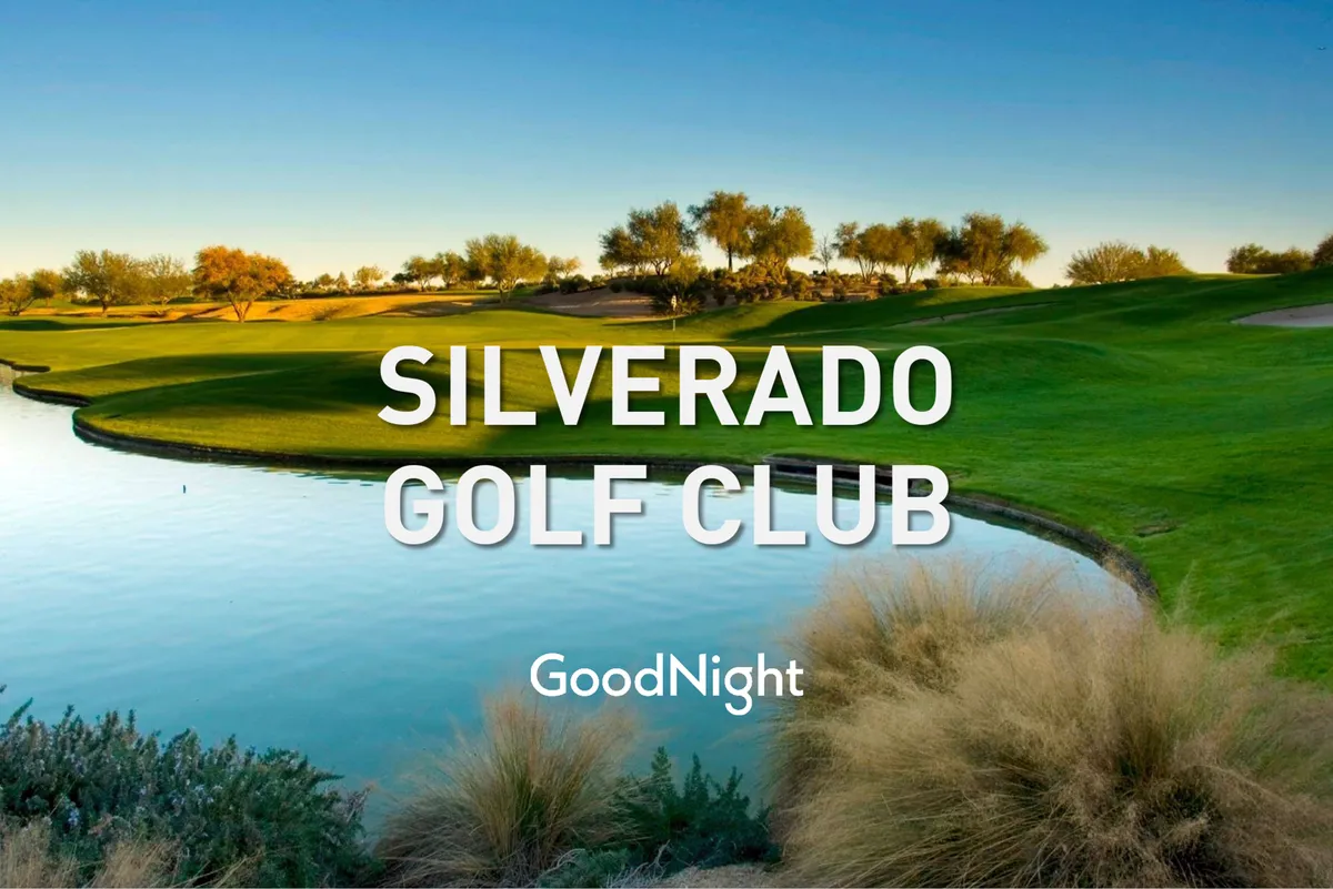 A picturesque exterior shot featuring a golf course with lush greenery and a serene lake. The setting sun creates a warm, inviting atmosphere, and the scene is framed by gentle slopes and manicured fairways.